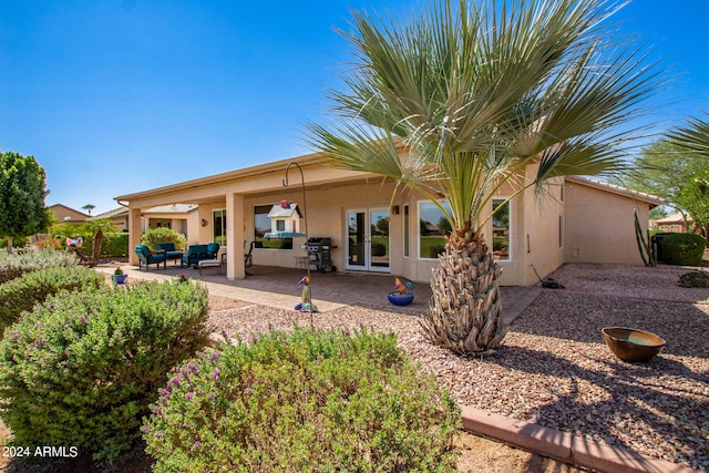 rear view of property with outdoor lounge area, ceiling fan, french doors, and a patio area