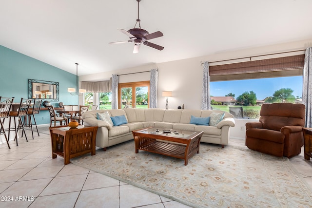 living room featuring lofted ceiling, ceiling fan, and light tile patterned floors