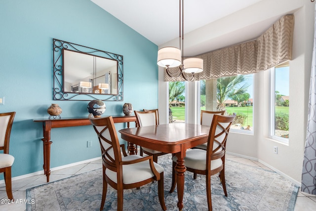 dining room featuring light tile patterned floors and vaulted ceiling