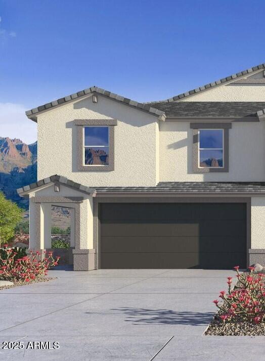 view of front of home with concrete driveway, a mountain view, an attached garage, and stucco siding