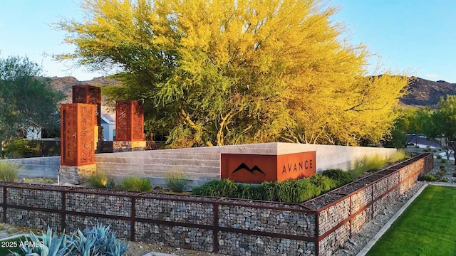 community / neighborhood sign featuring a mountain view and fence