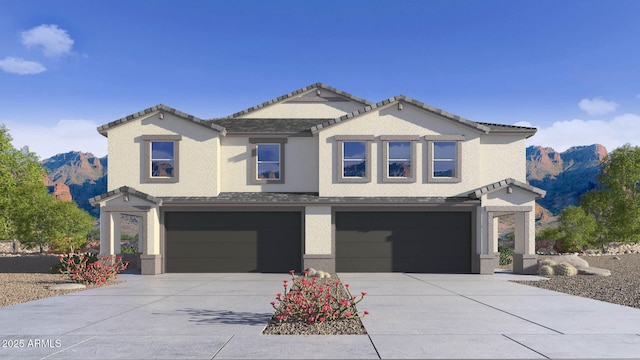 view of front facade with concrete driveway, a mountain view, an attached garage, and stucco siding