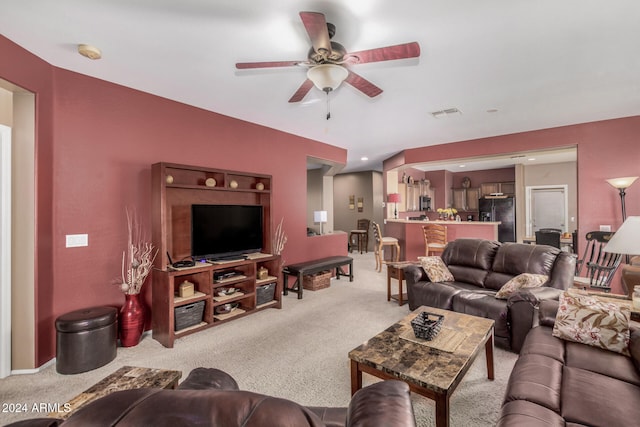 carpeted living room featuring ceiling fan