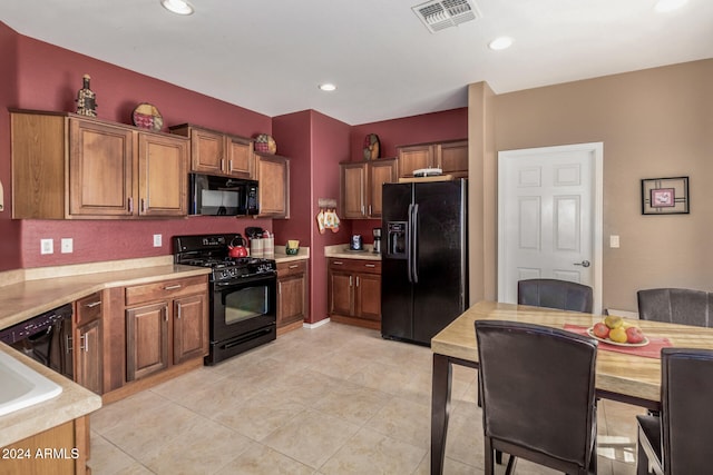 kitchen with light tile patterned flooring and black appliances