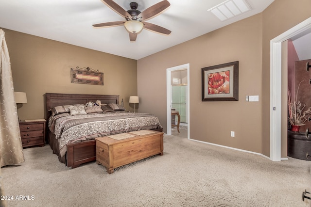 bedroom with light colored carpet, ceiling fan, and ensuite bath