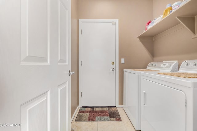 clothes washing area featuring washer and clothes dryer and light tile patterned floors