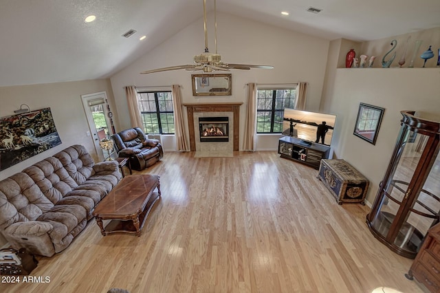 living area with light wood-style flooring, a tile fireplace, and visible vents