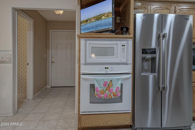 kitchen featuring white appliances and baseboards