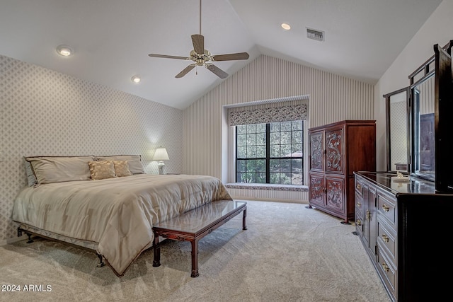 bedroom with light colored carpet, visible vents, a ceiling fan, vaulted ceiling, and wallpapered walls