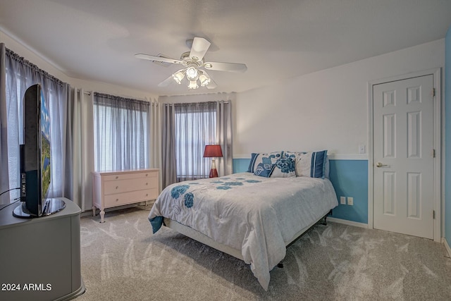 bedroom featuring light carpet, ceiling fan, and baseboards