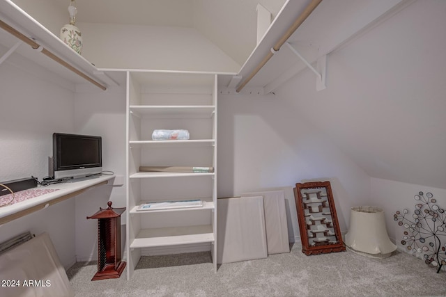 spacious closet featuring vaulted ceiling and light colored carpet