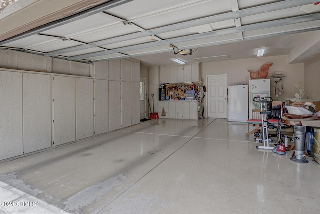 garage featuring a garage door opener and freestanding refrigerator