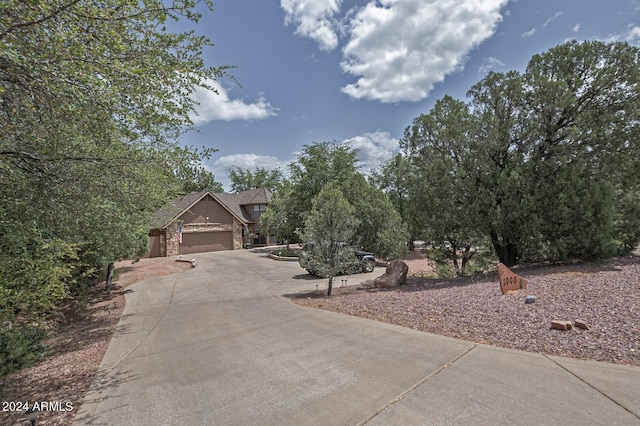 view of front of home featuring driveway, an attached garage, and brick siding