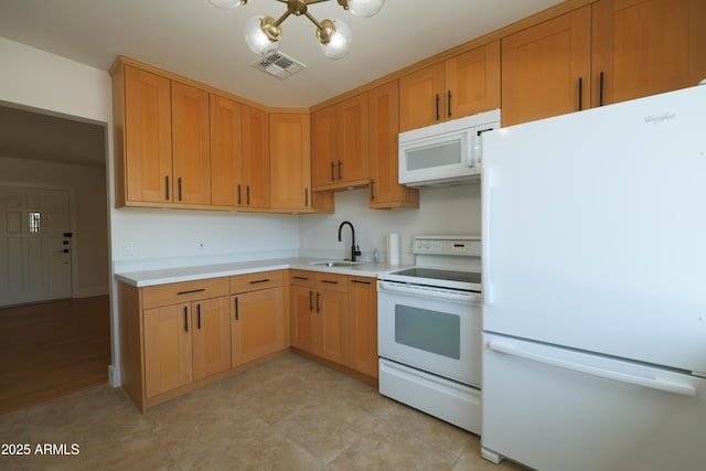 kitchen with white appliances, a sink, a chandelier, and light countertops