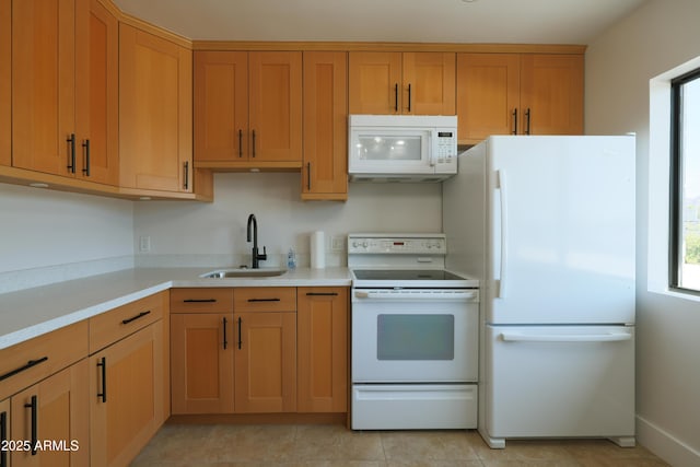 kitchen with white appliances, a sink, light countertops, and light tile patterned floors