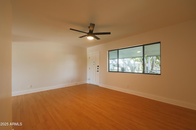 unfurnished room featuring light wood-style floors, a ceiling fan, and baseboards