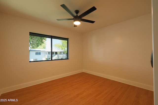 spare room with light wood-style flooring, baseboards, and ceiling fan