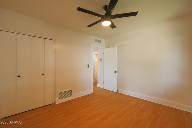 unfurnished bedroom with baseboards, light wood-style floors, a closet, and ceiling fan