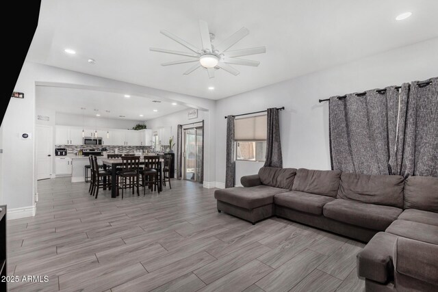 23848 W Grove St, Buckeye, AZ 85326 - living room with light wood-style flooring, a ceiling fan, recessed lighting, and baseboards
