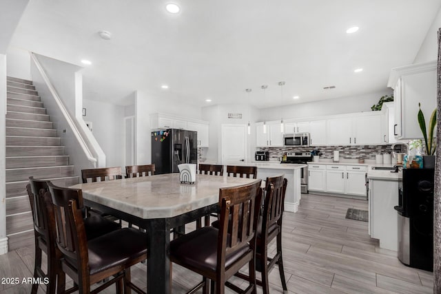 23848 W Grove St, Buckeye, AZ 85326 - dining space with recessed lighting, light wood-style flooring, visible vents, and stairs