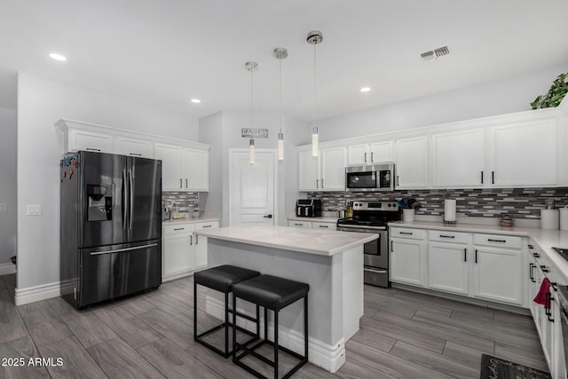 23848 W Grove St, Buckeye, AZ 85326 - kitchen featuring tasteful backsplash, a center island, white cabinets, visible vents, and appliances with stainless steel finishes