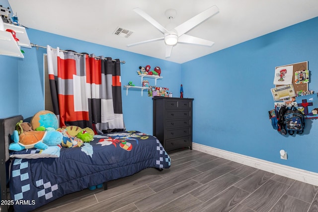 23848 W Grove St, Buckeye, AZ 85326 - bedroom with visible vents, baseboards, a ceiling fan, and wood finish floors