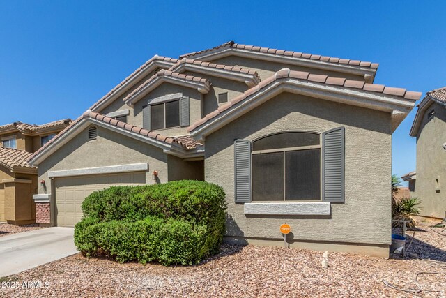 23848 W Grove St, Buckeye, AZ 85326 - mediterranean / spanish-style house with concrete driveway, a tile roof, a garage, and stucco siding