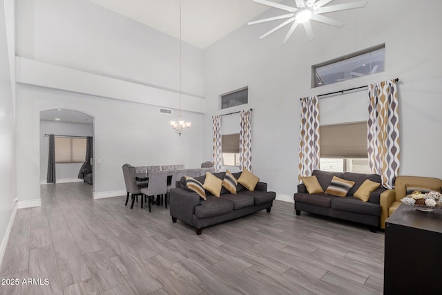 23848 W Grove St, Buckeye, AZ 85326 - living area featuring visible vents, arched walkways, light wood finished floors, ceiling fan with notable chandelier, and high vaulted ceiling