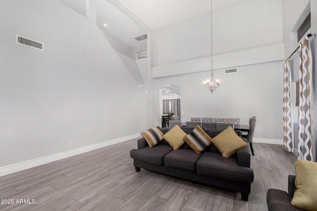 23848 W Grove St, Buckeye, AZ 85326 - living area with arched walkways, wood finished floors, a notable chandelier, and visible vents
