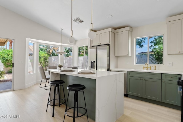 732 W Sagebrush St, Gilbert, AZ 85233 - kitchen featuring stainless steel appliances, a sink, light countertops, green cabinets, and a kitchen breakfast bar