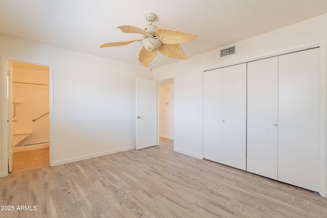 1124 S Longwood Loop, Mesa, AZ 85208 - unfurnished bedroom featuring light wood-style floors, a closet, ensuite bath, ceiling fan, and a textured ceiling