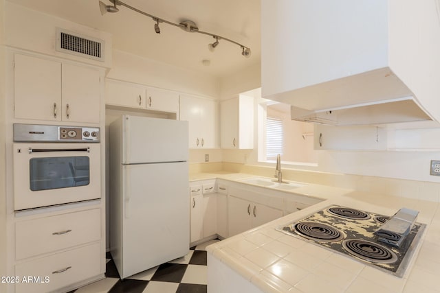 1124 S Longwood Loop, Mesa, AZ 85208 - kitchen with white appliances, tile countertops, tile patterned floors, wall chimney exhaust hood, and white cabinetry