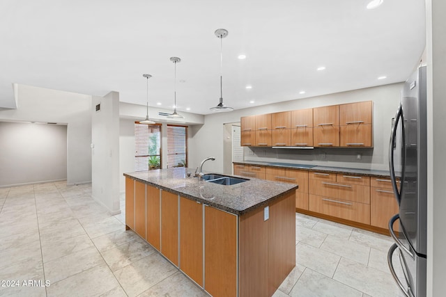 7385 E Pleasant Run, Scottsdale, AZ 85258 - kitchen with freestanding refrigerator, dark stone counters, modern cabinets, recessed lighting, and a kitchen island with sink