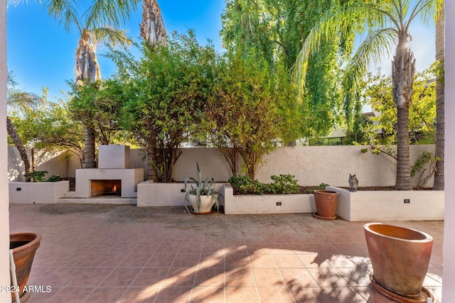 7385 E Pleasant Run, Scottsdale, AZ 85258 - fenced backyard with a warm lit fireplace and a patio area