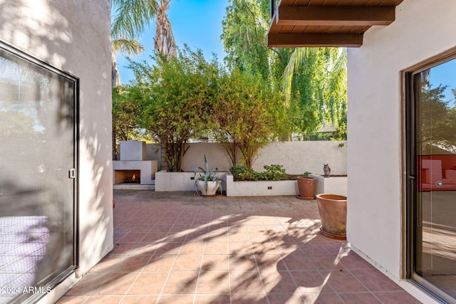 7385 E Pleasant Run, Scottsdale, AZ 85258 - fenced backyard featuring a lit fireplace and a patio area