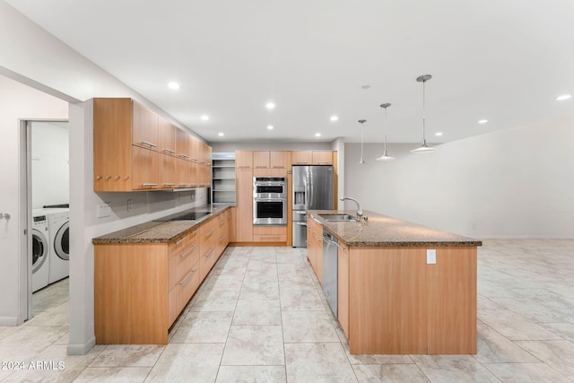 7385 E Pleasant Run, Scottsdale, AZ 85258 - kitchen featuring stainless steel appliances, washing machine and dryer, dark stone countertops, an island with sink, and recessed lighting