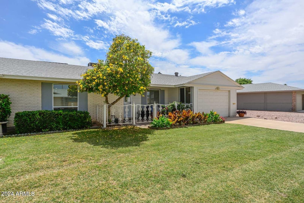 ranch-style home with a front yard, a porch, and a garage