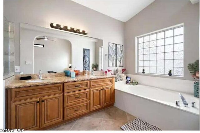 bathroom with vanity, lofted ceiling, tile patterned flooring, ceiling fan, and a tub