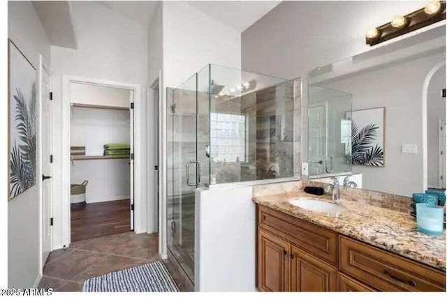 bathroom featuring tile patterned flooring, vanity, and a shower with shower door