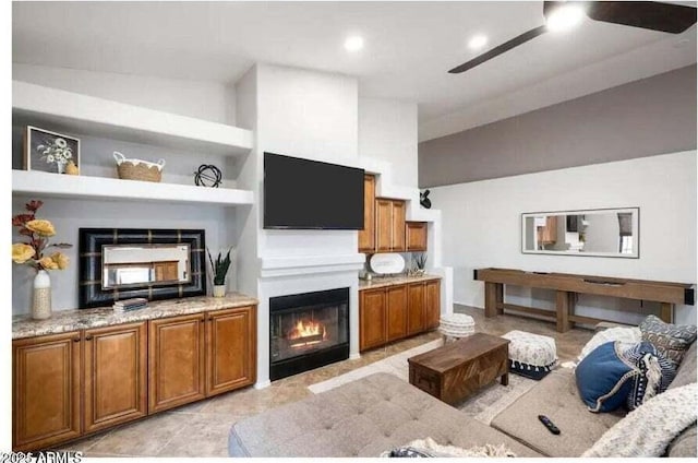 living room featuring built in shelves, ceiling fan, and lofted ceiling