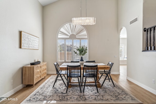 dining area featuring a chandelier, a healthy amount of sunlight, and wood-type flooring