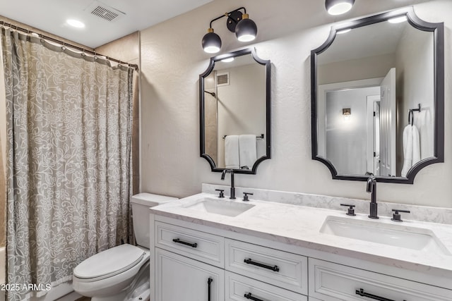 bathroom with toilet, vanity, and walk in shower