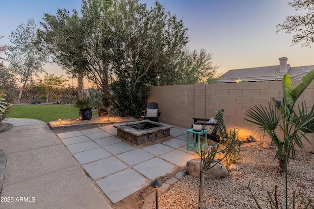 patio terrace at dusk featuring an outdoor fire pit