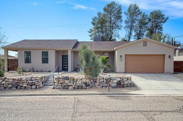 single story home with a garage, driveway, and stucco siding