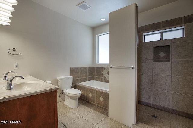 bathroom with double vanity, visible vents, tile patterned floors, a garden tub, and a sink