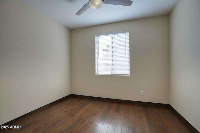 spare room with dark wood-type flooring and a ceiling fan