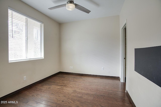 spare room with dark wood-style floors, ceiling fan, and baseboards