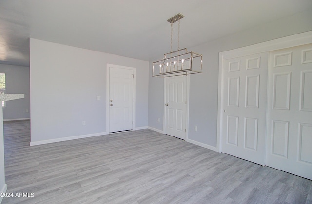 unfurnished dining area with baseboards and light wood-style floors