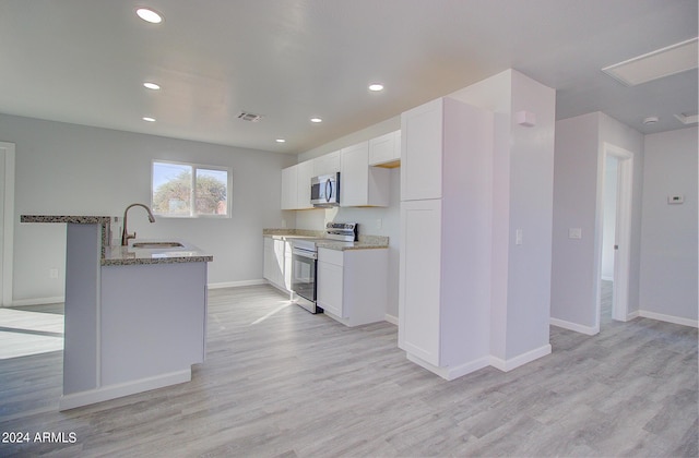 kitchen featuring visible vents, a sink, light stone counters, white cabinetry, and appliances with stainless steel finishes