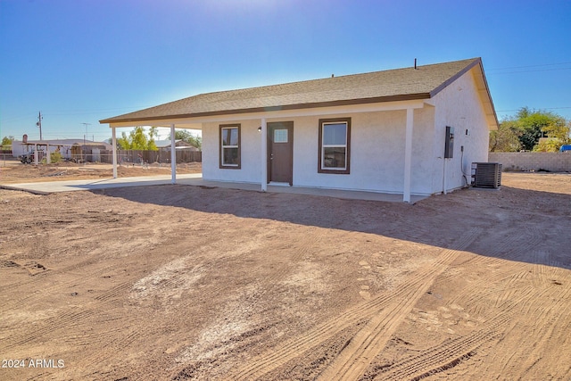 view of front of property featuring central air condition unit, stucco siding, and fence